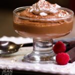 Chocolate Mousse in a dessert dish with a raspberry in front.