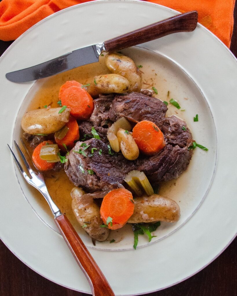 Pot Roast on a white dinner plate with knife and fork