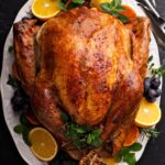 Roast Turkey on a white platter with garnish.