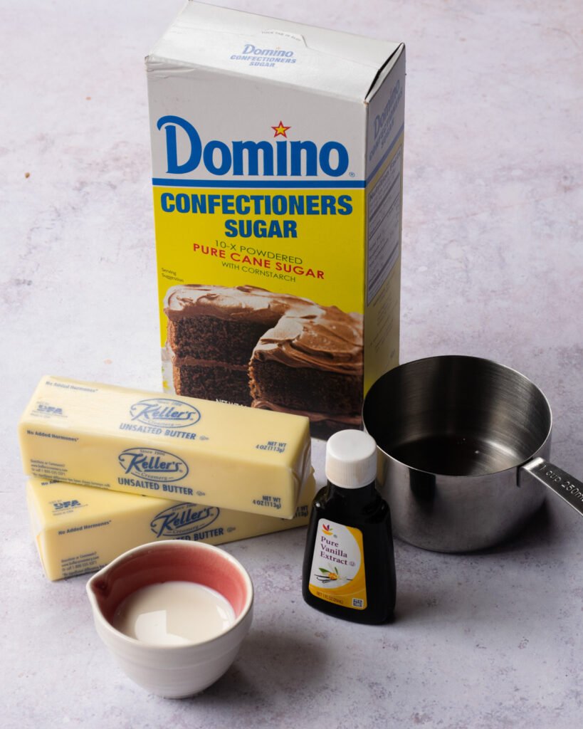 Ingredients on a counter - powdered sugar, butter, vanilla and light cream.