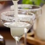 Margarita being poured into a tulip glass.