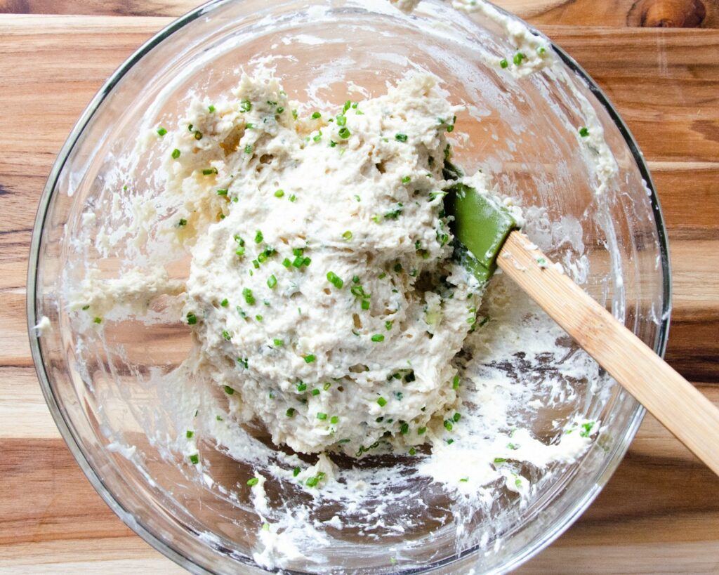 Dumpling batter in a glass bowl with a green spatula - part of chicken and dumplings.