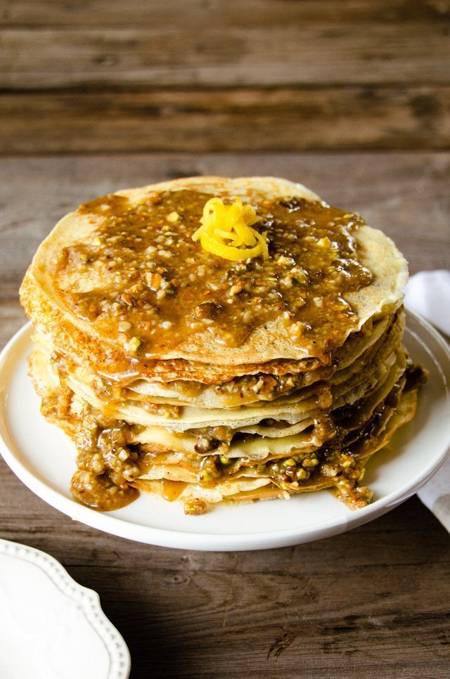 Baklava crêpe cake on a white cake stand.