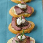 Beef and Mushroom Crostini on a turquoise napkin.