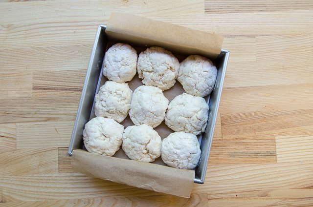 Buttermilk Biscuits raw in a cake pan lined with parchment paper.