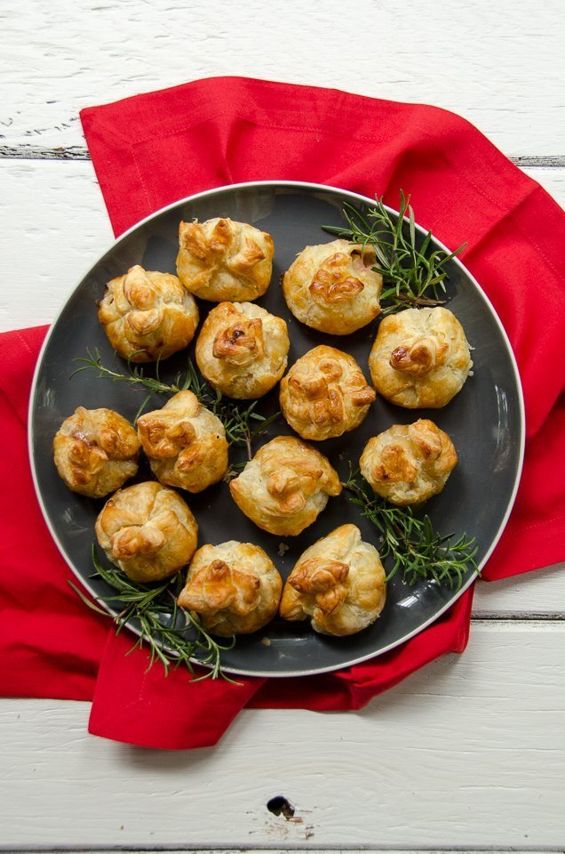 Straight down shot of mini Brie bites on a grey plate with a red napkin on a white table.