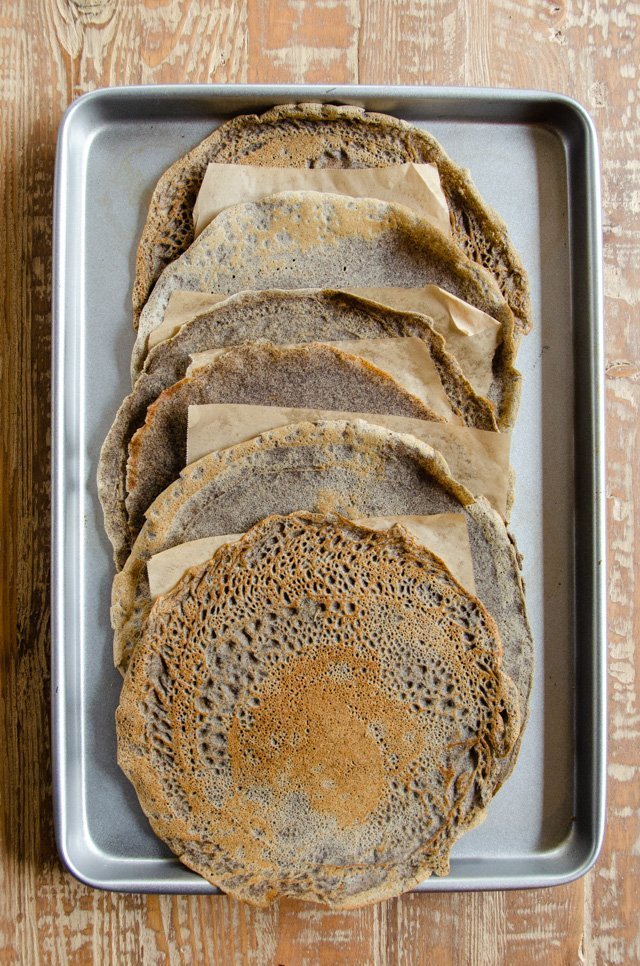 Buckwheat crêpes shingled on a sheet pan.