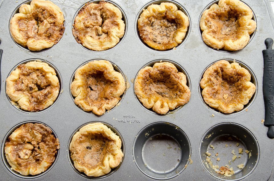 Butter tarts in a muffin pan with two missing.