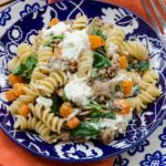 Butternut Squash Pasta toss in a blue and white bowl with an orange napkin.