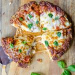 Cauliflower Pan Pizza on a wooden cutting board