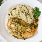 Chicken Francaise on a white plate with angel hair pasta.
