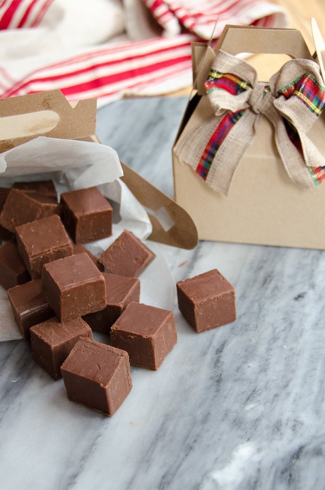 Basic chocolate fudge on a marble counter with gift boxes and ribbons.