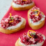 Cranberry orange crostini on a pink napkin.