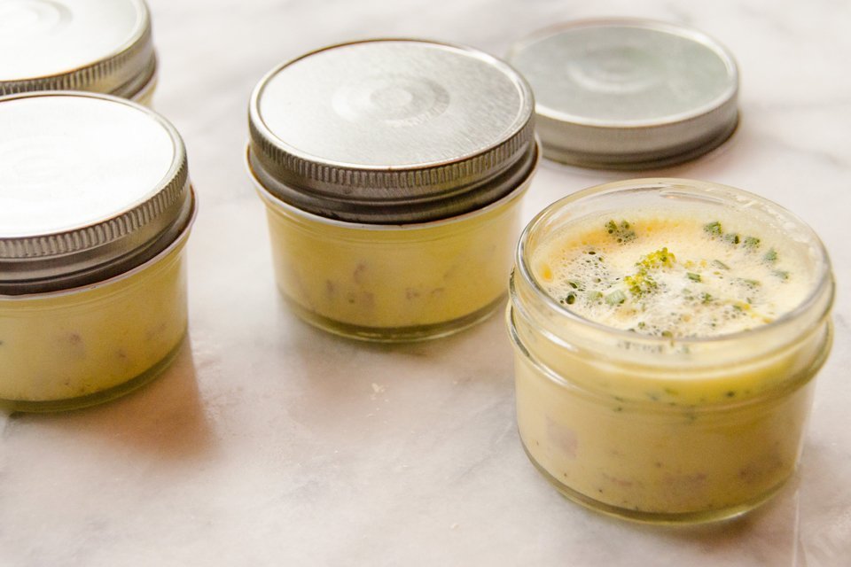 4 jars of Instant Egg Bites on a marble table with one jar open.