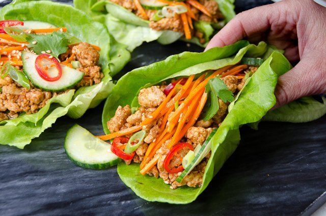 Hand holding Korean BBQ Chicken Lettuce Wrap.