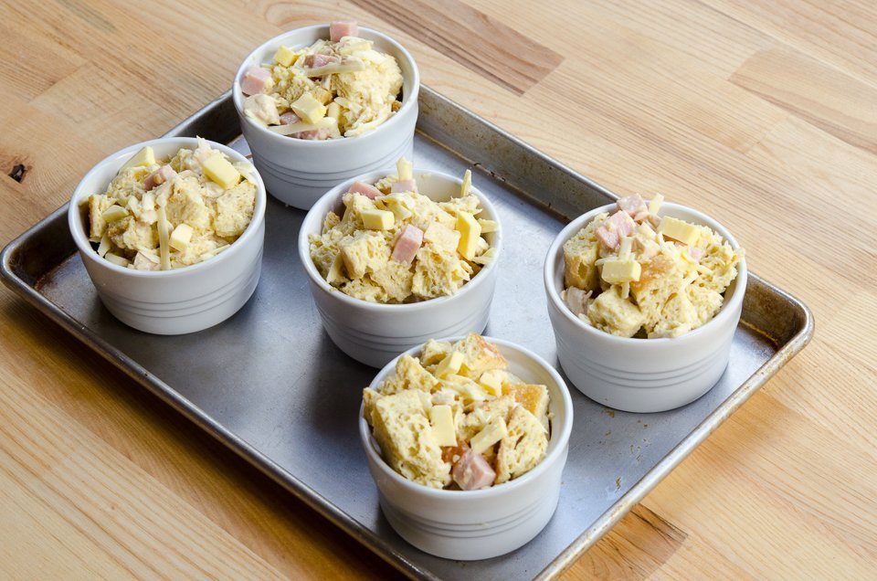 5 raw monte cristo bread puddings on a sheet pan.