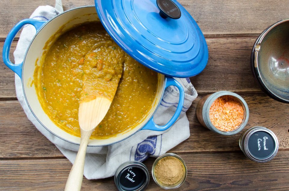 A Dutch oven of mulligatawny with a wooden spoon.