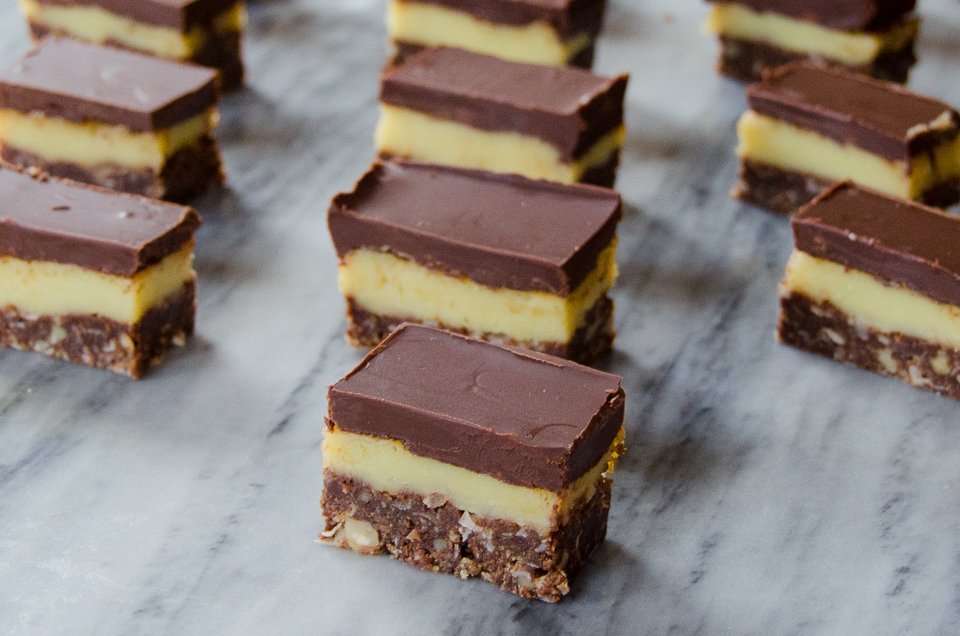 Nanaimo Bars scattered on grey marble.