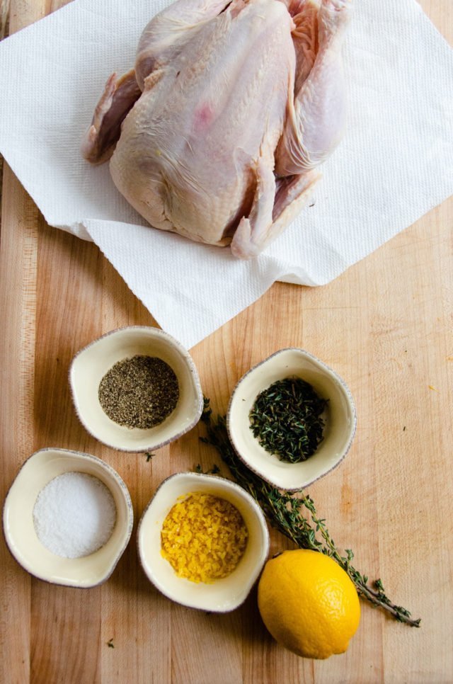 Ingredients for roast chicken on a cutting board.