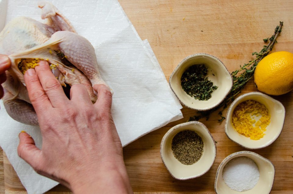 Ingredients for roast chicken on a cutting board.