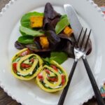Egg Roulades on a white plate with side salad.