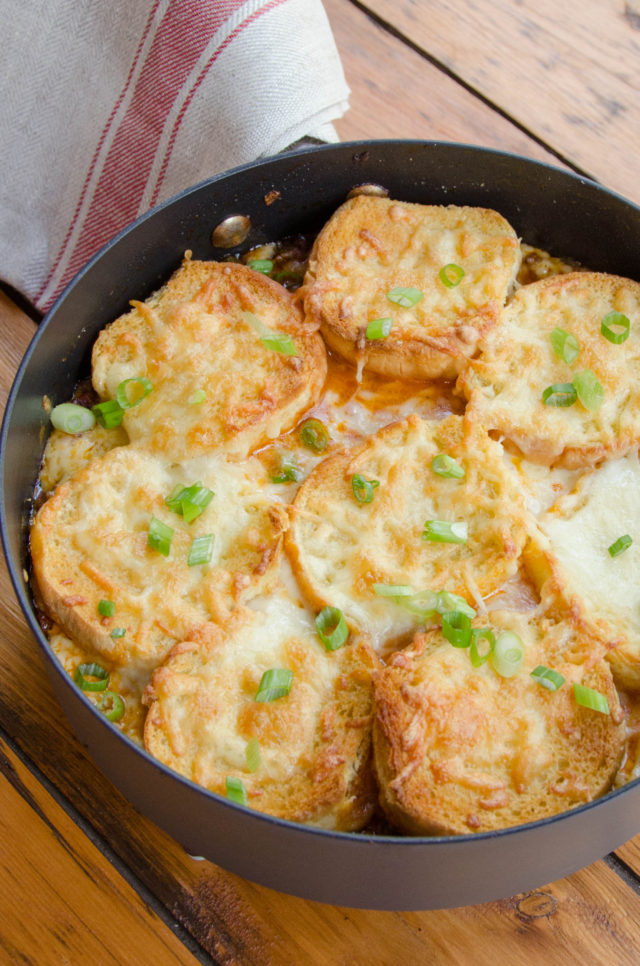 Sloppy Joe Casserole in a sauté pan on a wooden table with napkin over the handle.