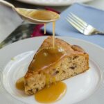 Sticky Toffee Pudding with a spoon drizzling sauce on top.