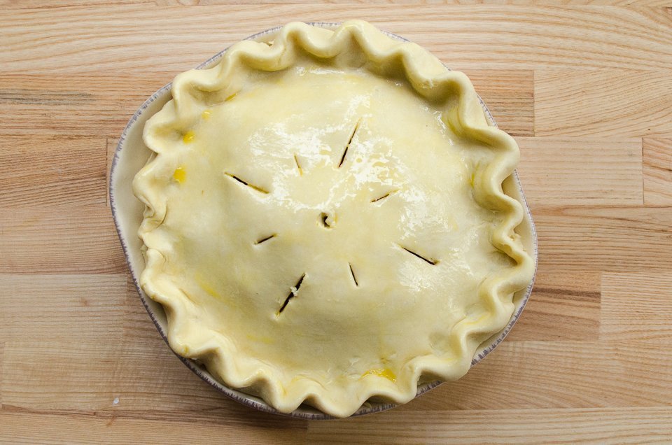A raw tourtière with decorative pastry.