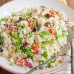Turkey Couscous Salad in a white bowl on a wooden table.