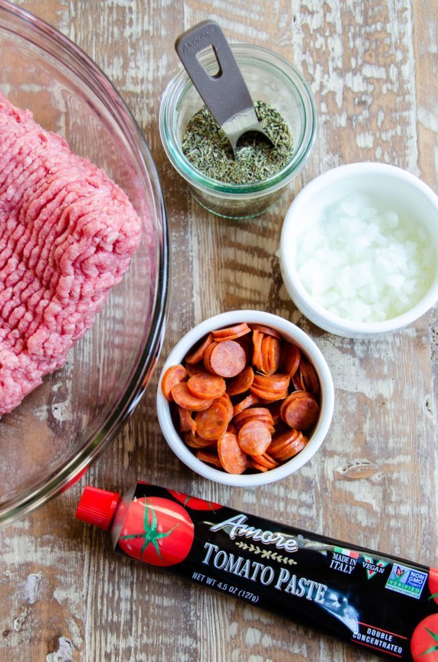 Ingredients for air-fried pizza burgers - beef, tomato paste, onion, pepperoni, Italian seasoning.