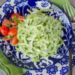 Spinach Fettuccine Alfredo on a blue and white plate with a green napkin.