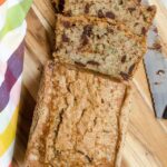 Double Chocolate Zucchini Bread on a cutting board with a few slices cut out and a colorful napkin.