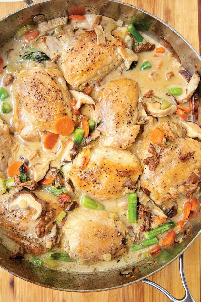 Chicken Fricassee in a stainless steel sauté pan on a wooden countertop