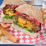 Inside Out Cheeseburgers on a red checkered paper lined tray.