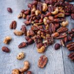 Spiced nuts scattered on a wooden surface