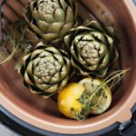 Pressure Steamed Artichokes on a rack in a pressure cooker.