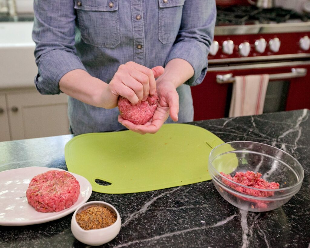 Making an indentation in a burger patty.