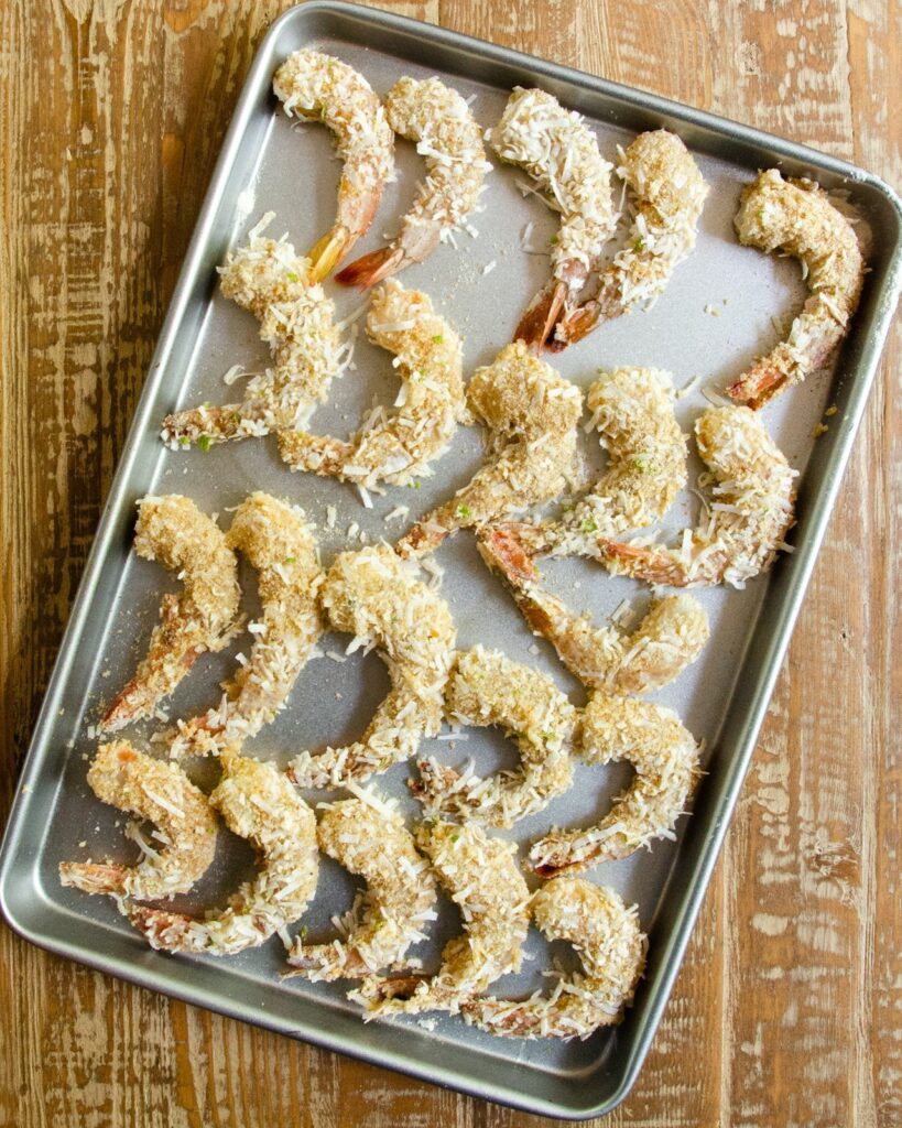 A baking sheet of Coconut shrimp breaded and ready to fry.