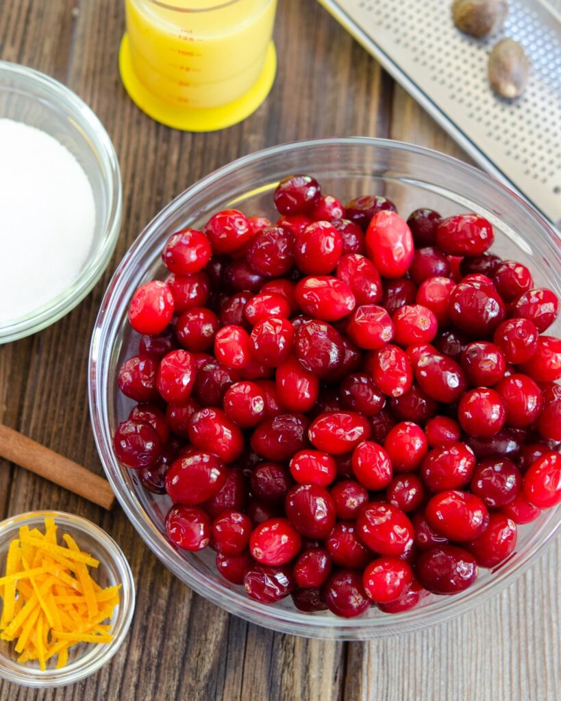 Ingredients for Cranberry Sauce on a wooden table.