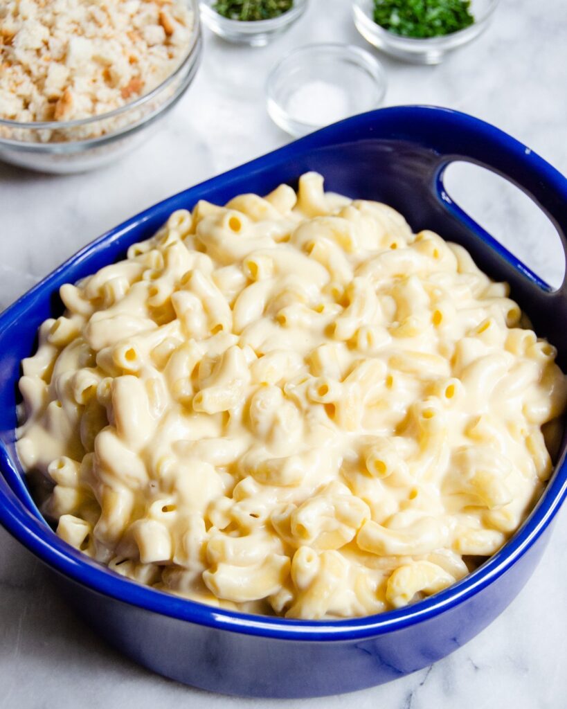 Macaroni and cheese in a blue casserole dish, unbaked.