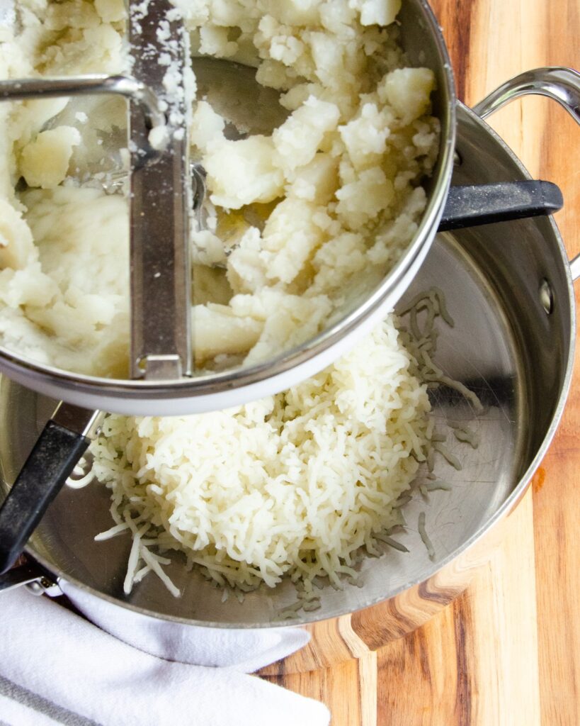 Potatoes being milled through a food mill.
