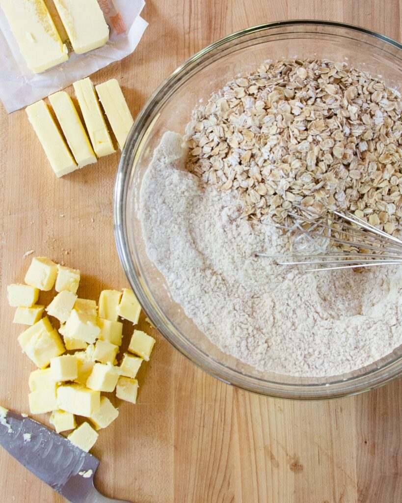 Dry ingredients for scones in a bowl with cubed butter next to it.