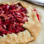 Free Form Strawberry Rhubarb tart on parchment paper on a baking tray.
