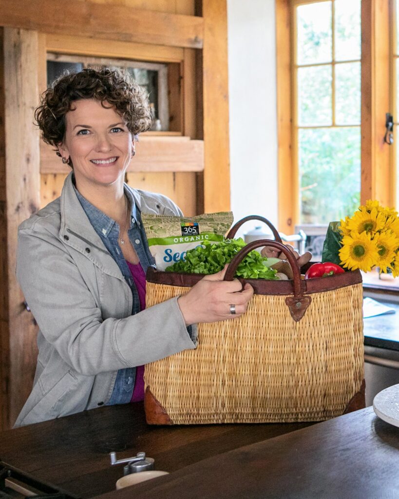 Meredith in barn with a shopping bag on the counter.