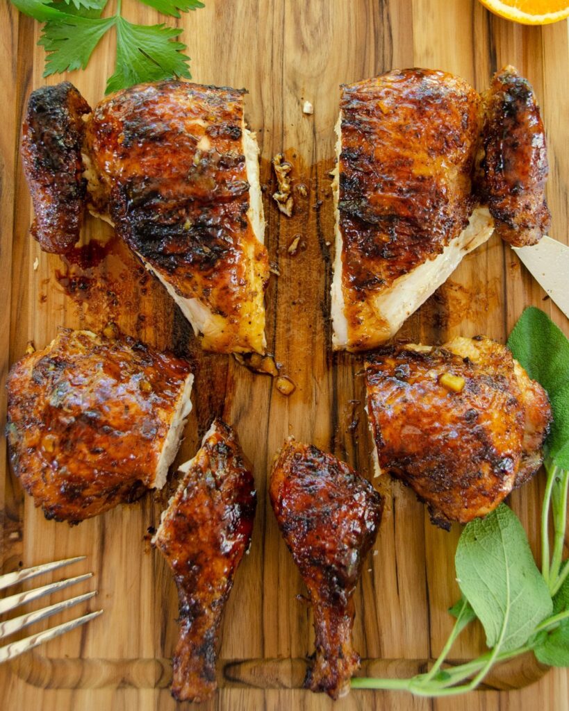 Chicken cut into 6 pieces on a wooden cutting board.