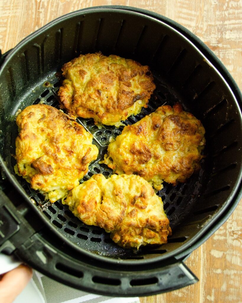 Air-fried chicken pieces in an air fryer basket.