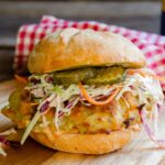 Air Fried Chicken Sandwich on a wooden board with a red checkered napkin in the background.