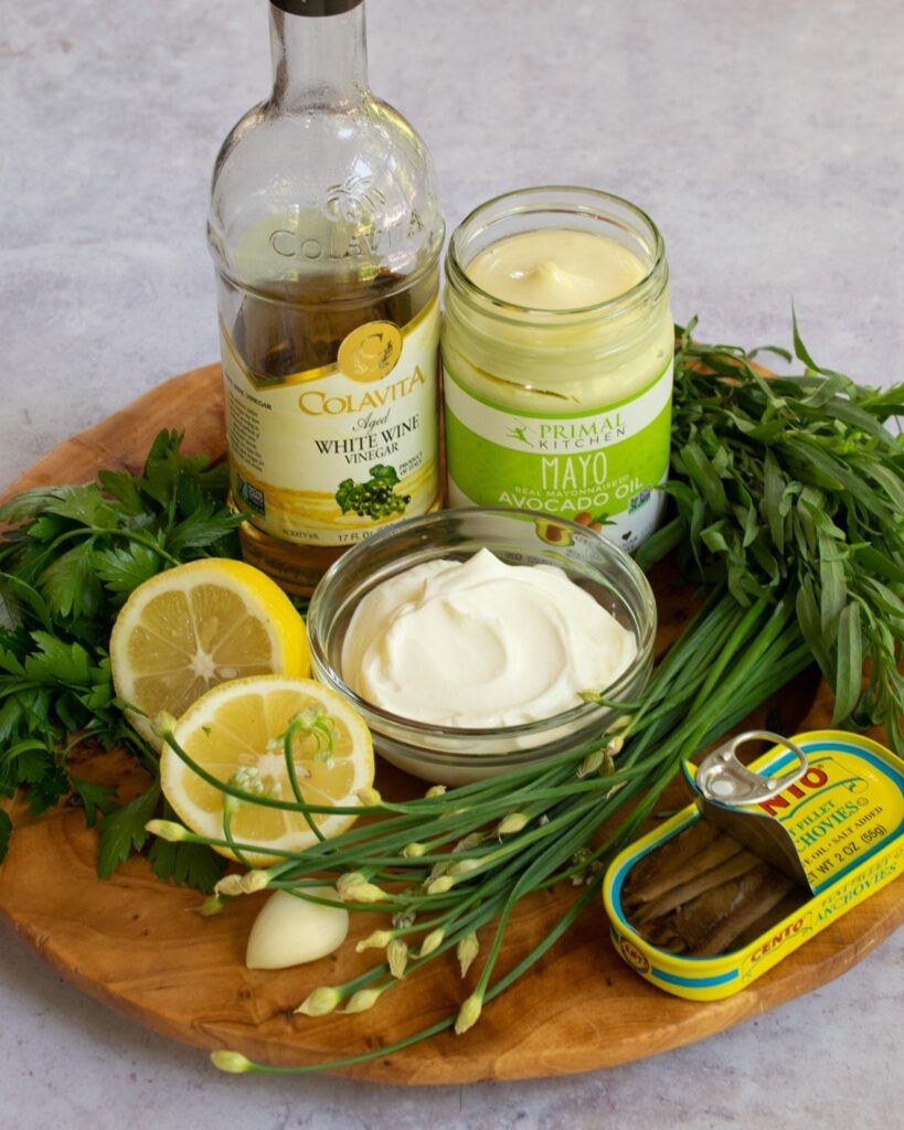 Ingredients for green goddess dressing on a wooden tray.