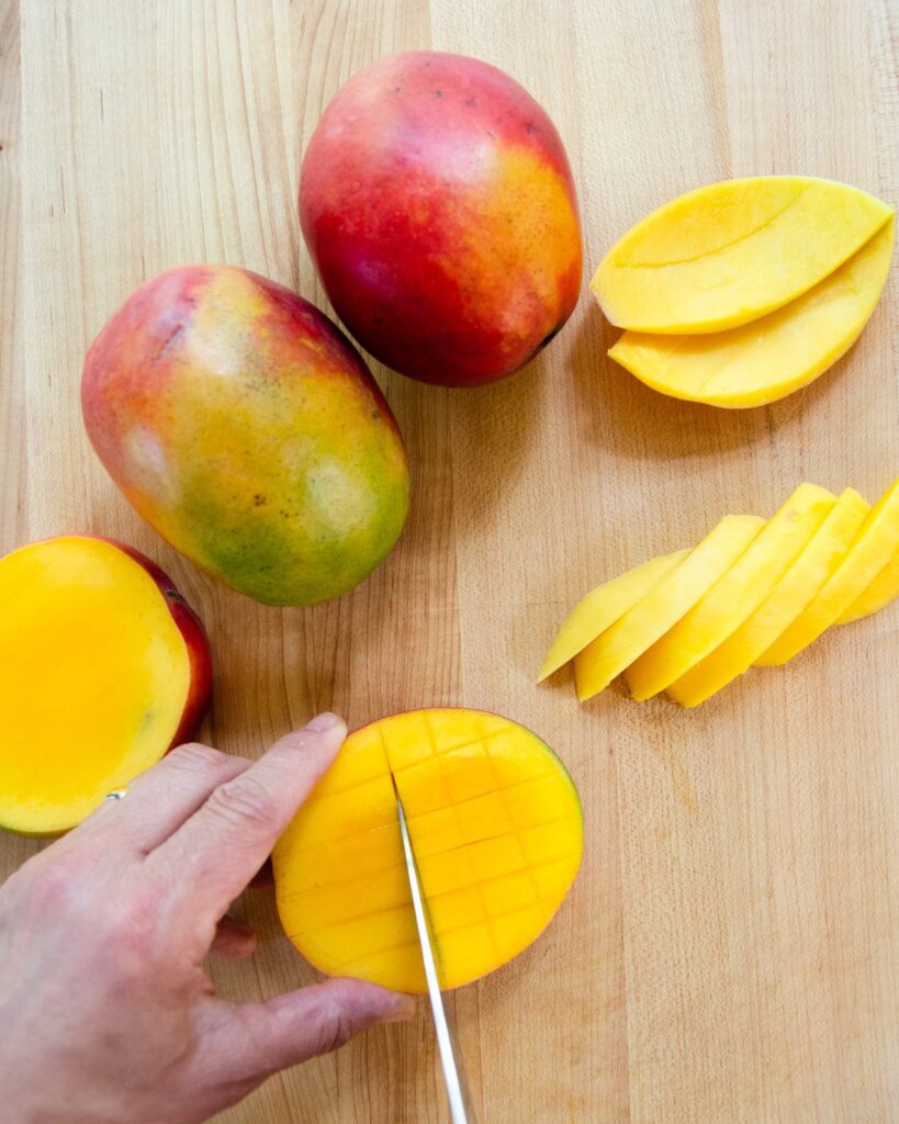 A mango cutting cross hatch marks in a mango.