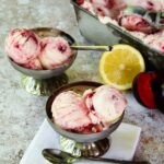 Plum Lemon Buttermilk ice cream in two silver dishes with a loaf pan of ice cream in the background.